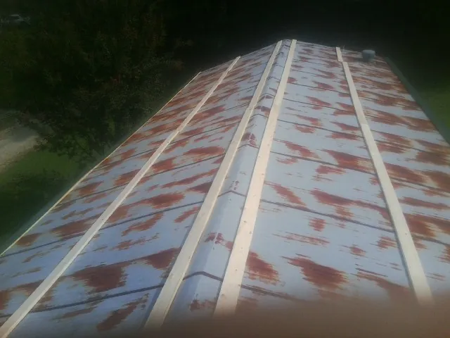 Rusted metal roof panels with new wood purlins before replacement — Storm Damage Roof Repair in Trumbull by Roofing Brothers
