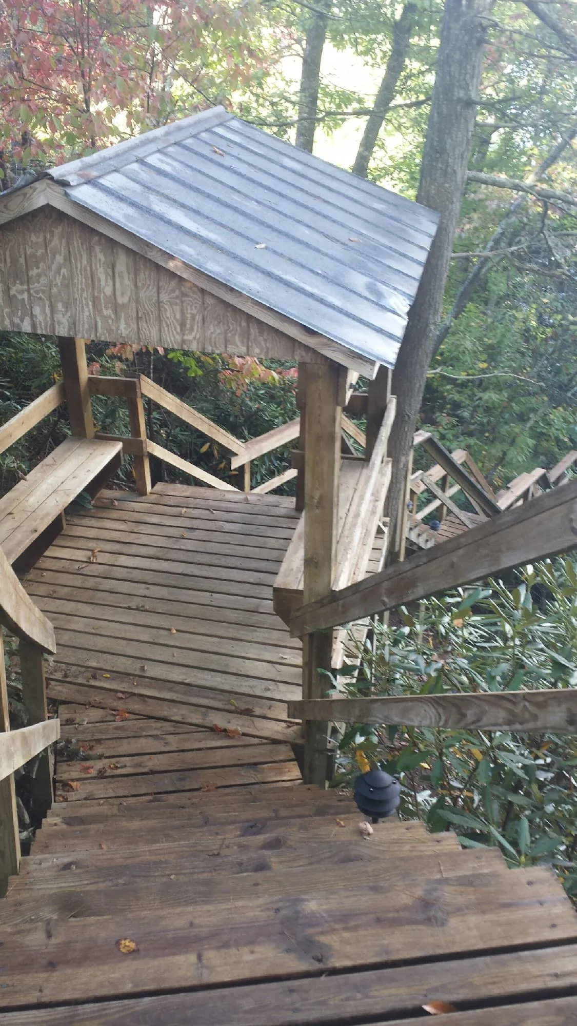 Metal roofed shelter over wooden steps on a wooded walkway — Skylight Repair & Installation work by our crew in Trumbull